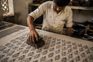 Artisan hand block printing fabric using traditional Bagru technique