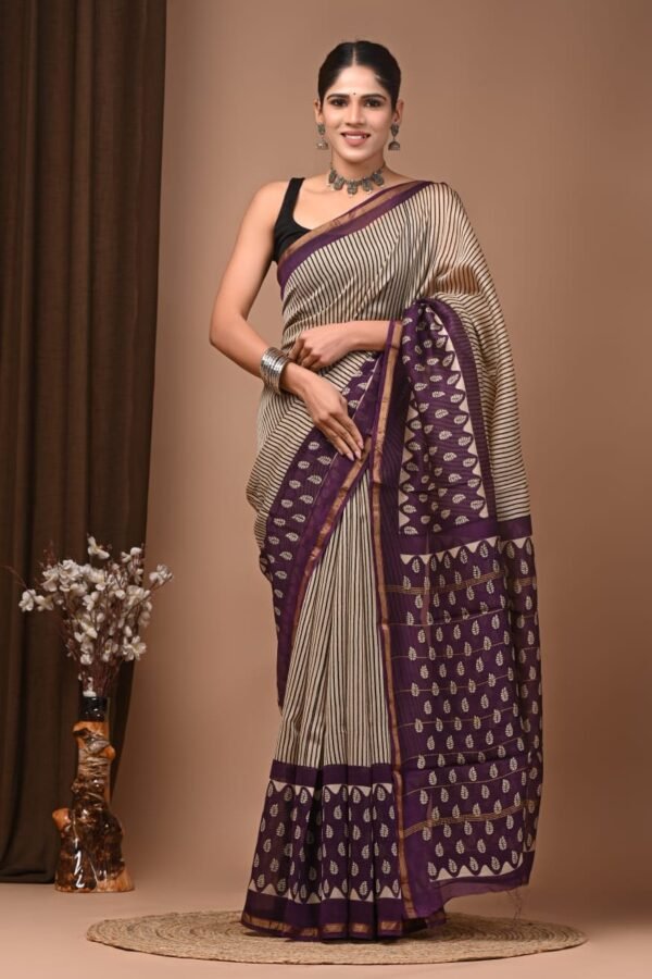 Woman in cream and purple Chanderi silk saree with striped body and hand block printed leaf border