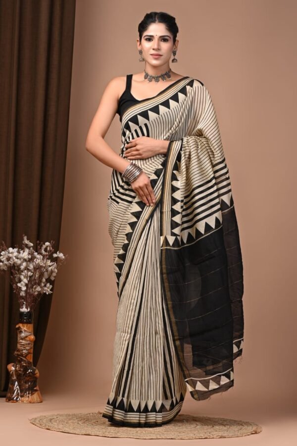 Woman draped in black and cream Chanderi silk saree with zigzag hand block print border