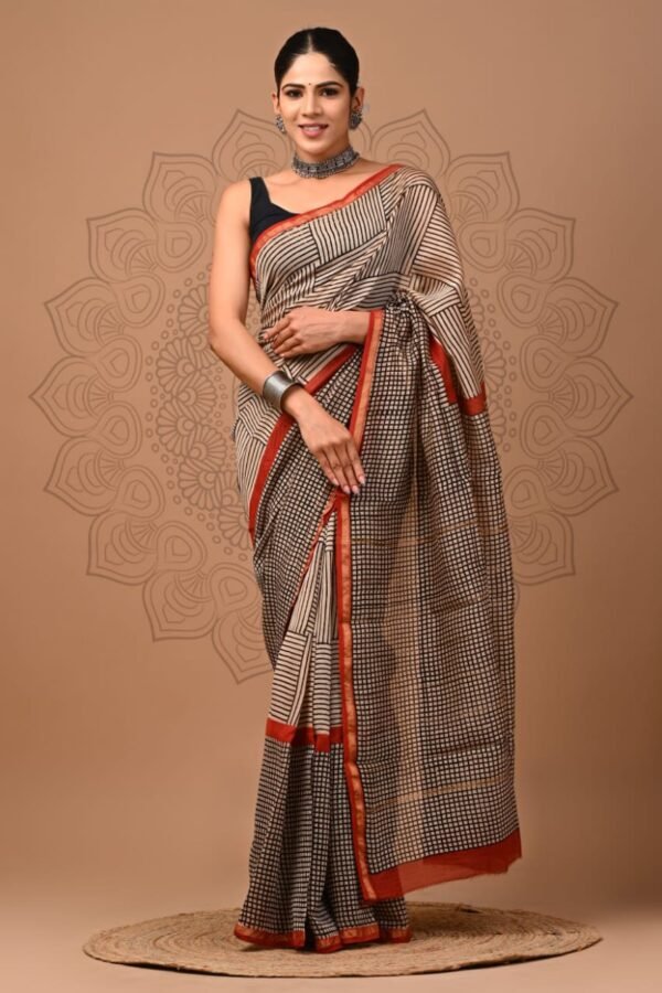 Woman wearing cream Chanderi silk saree with black checkered print and rust border