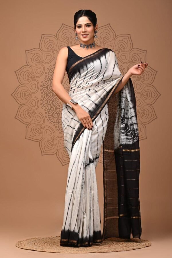 Woman draped in off-white Chanderi silk saree with black hand block wave print and golden border