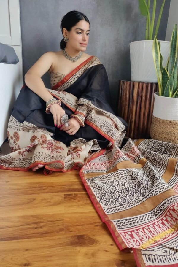 Woman draped in black Chanderi silk saree with Bagru hand block printed cream floral and geometric border