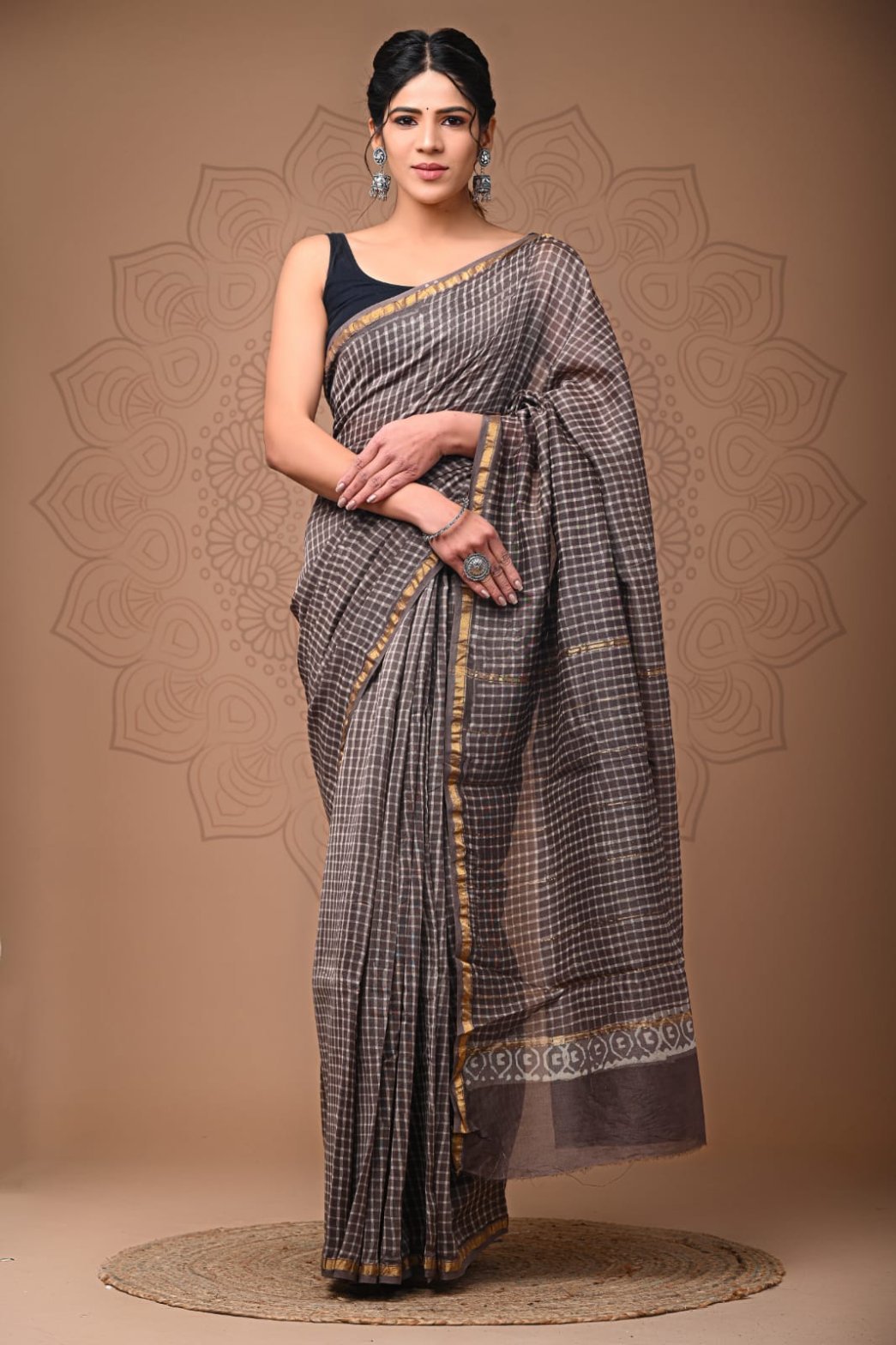 Woman draped in grey checkered Chanderi silk saree with gold zari border and paisley pallu