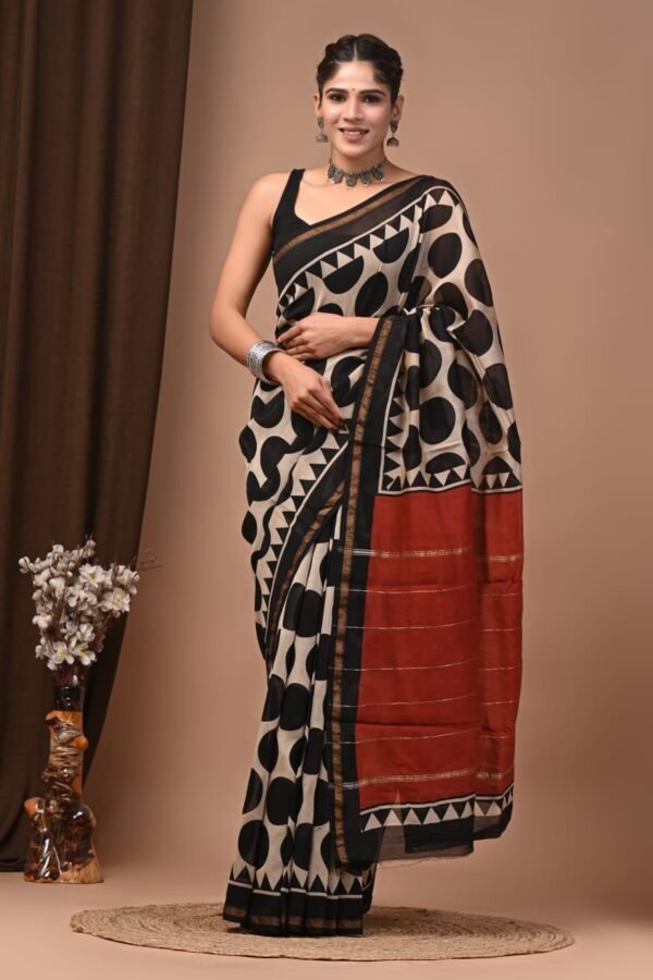 Woman wearing cream Chanderi silk saree with black polka dot print and rust-red pallu