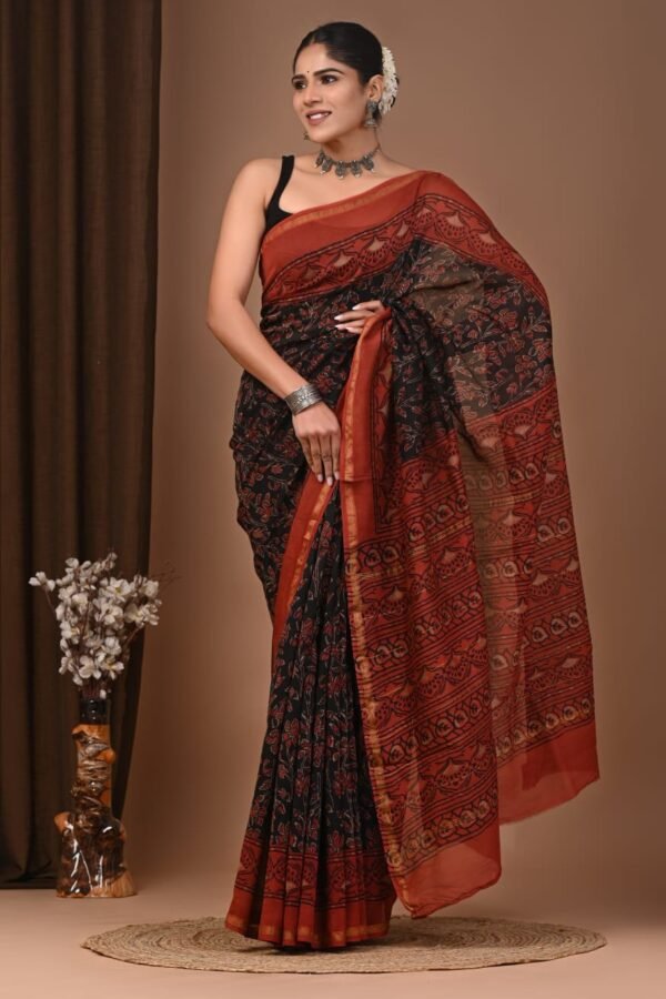 Woman draped in black Chanderi silk saree with rust red Bagru block printed floral border and pallu