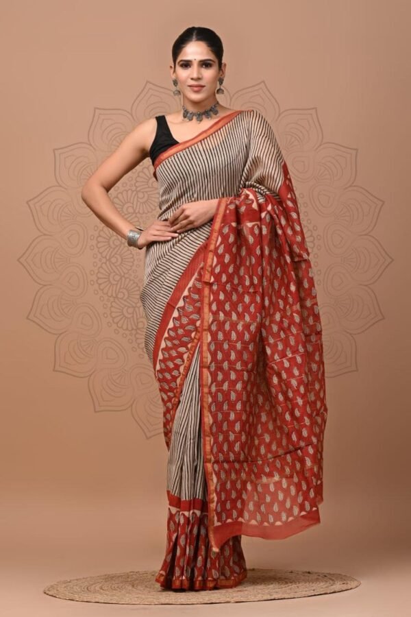 Woman wearing beige pinstripe Chanderi silk saree with rust-red leaf motif Bagru block print border