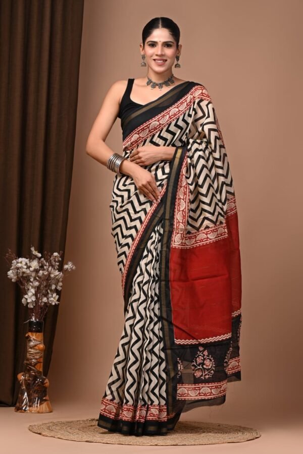 Woman wearing cream Chanderi silk saree with black chevron print and red Bagru block print border