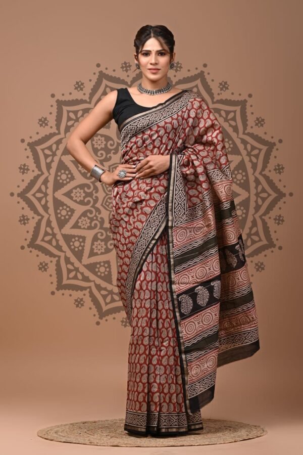 Woman wearing maroon Chanderi silk saree with Bagru hand block printed leaf booti and geometric border