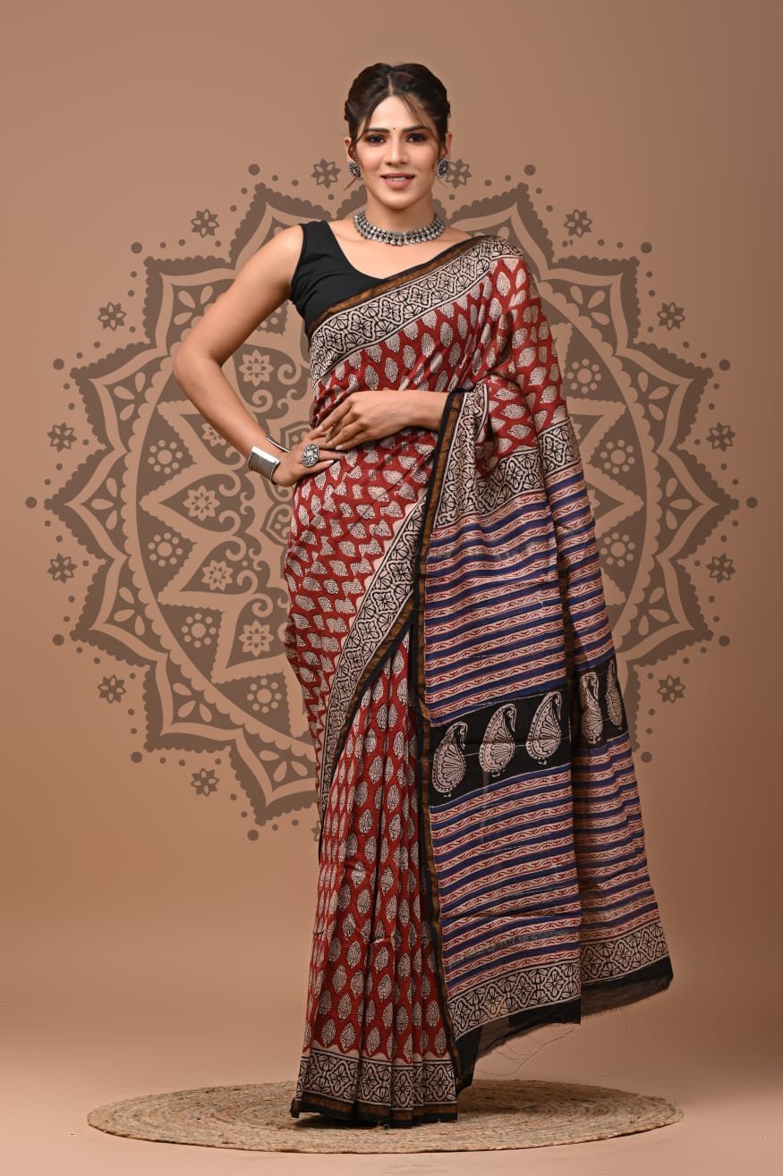 Woman wearing rust red Bagru hand block printed Chanderi silk saree with leaf booti and striped pallu