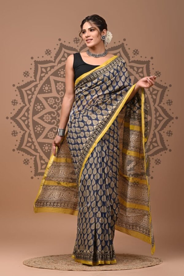 Woman draped in navy blue Chanderi silk saree with beige leaf print and mustard border, Bagru hand block print