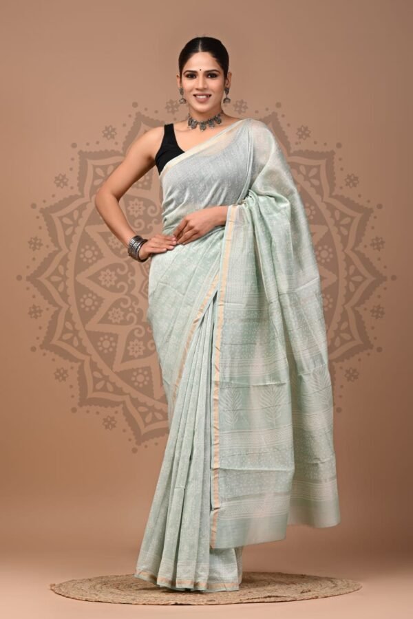 Woman wearing a mint green Chanderi silk saree with floral Bagru hand block print and gold border