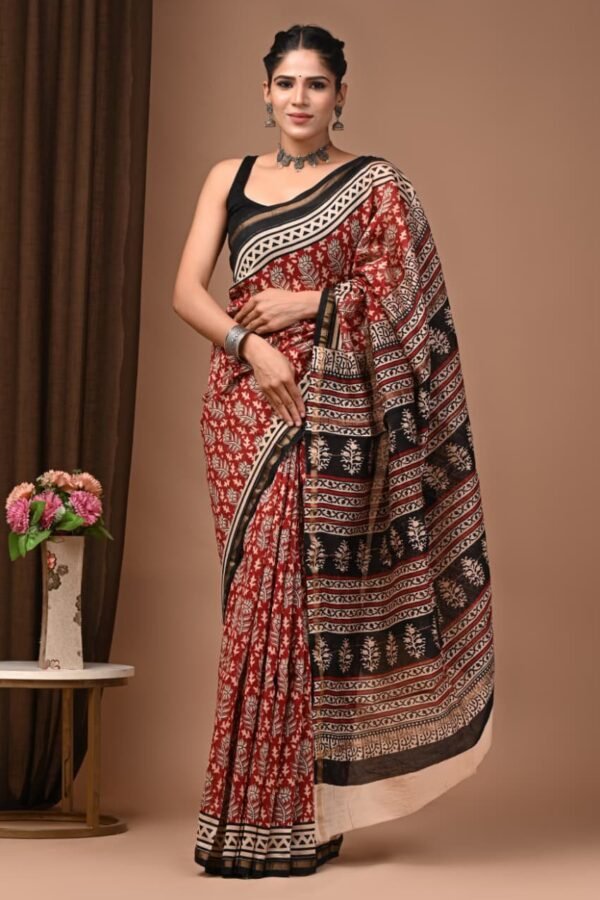 Woman wearing rust-red floral Bagru hand block printed Chanderi silk saree with black zigzag border
