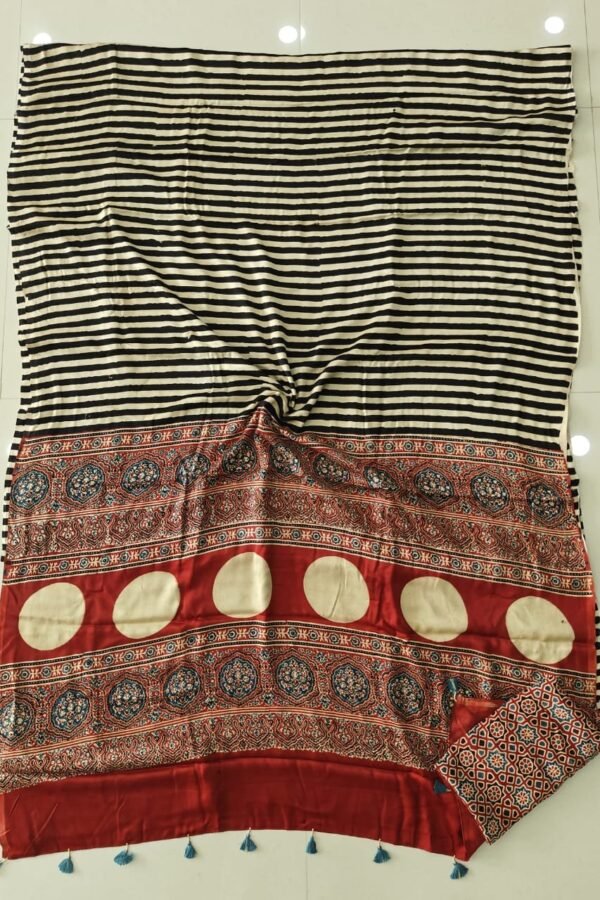 Black and cream striped Ajrakh print modal silk saree with rust red medallion border laid flat