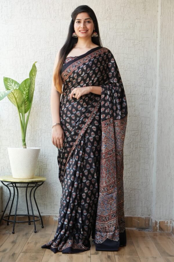 Woman wearing black Ajrakh print Modal silk saree with paisley booti and geometric pallu border