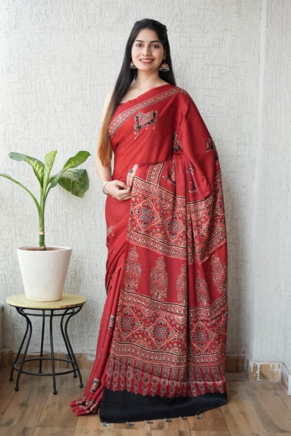 Woman wearing red Ajrakh print Modal silk saree with deer motifs and black border
