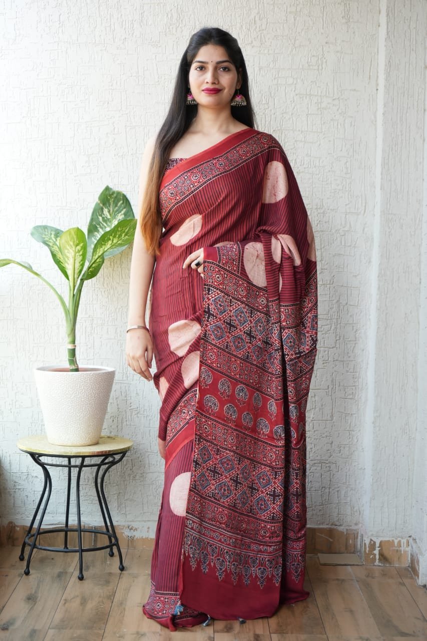 Woman wearing maroon Ajrakh print Modal Silk saree with circle motifs and diamond lattice pallu