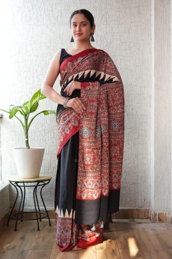 Woman wearing black Ajrakh print Modal silk saree with red floral medallion pallu and triangle border