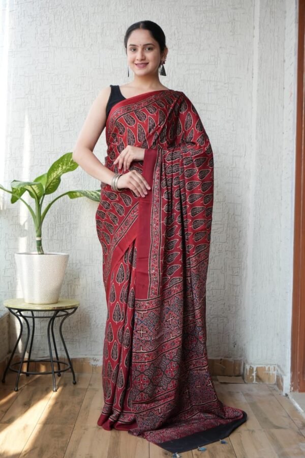 Woman wearing maroon Ajrakh print Modal silk saree with leaf motifs and geometric border