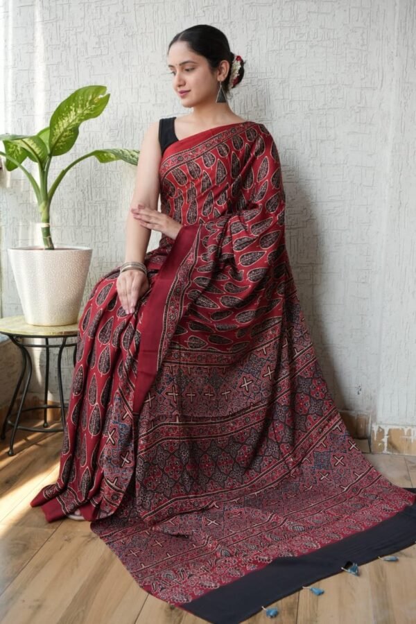 Woman draped in maroon Ajrakh print Modal silk saree with leaf motifs and geometric lattice border