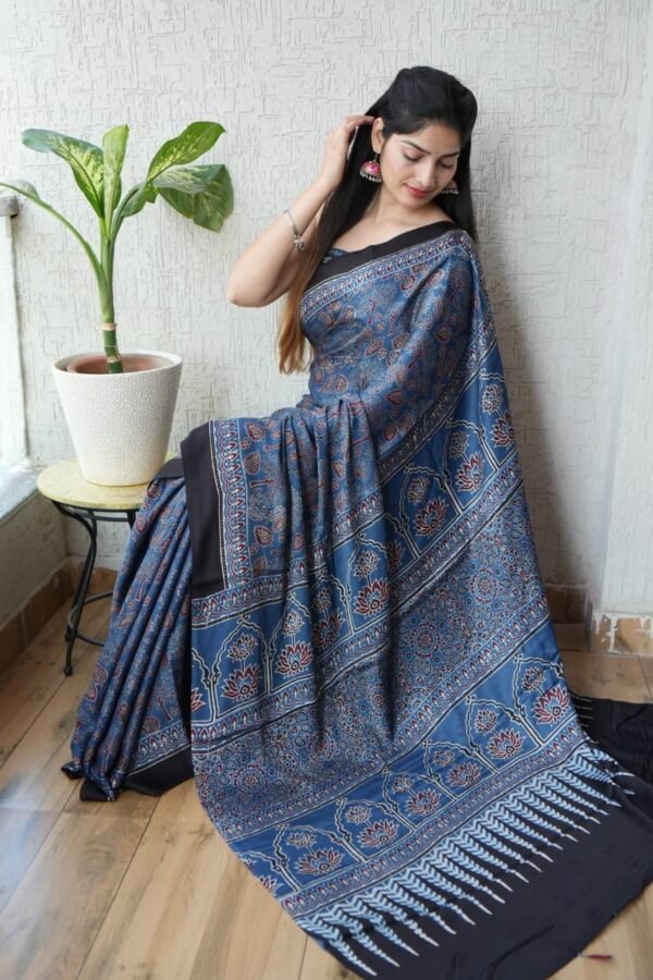 Woman draped in steel blue Ajrakh print Modal Silk saree with lotus temple pallu and black border