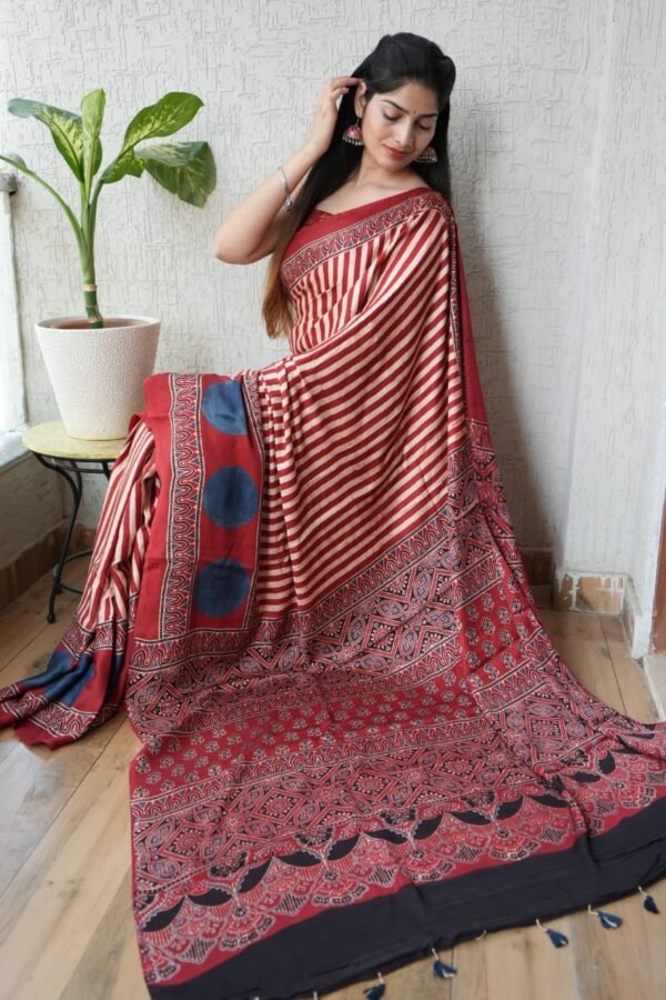 Woman draped in red and ivory striped Ajrakh print modal silk saree with indigo dot border and black pallu
