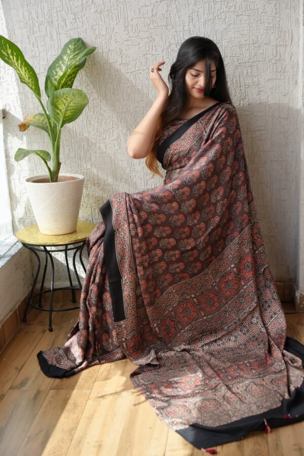 Woman draped in brown Ajrakh print Modal Silk saree with paisley booti and star medallion pallu
