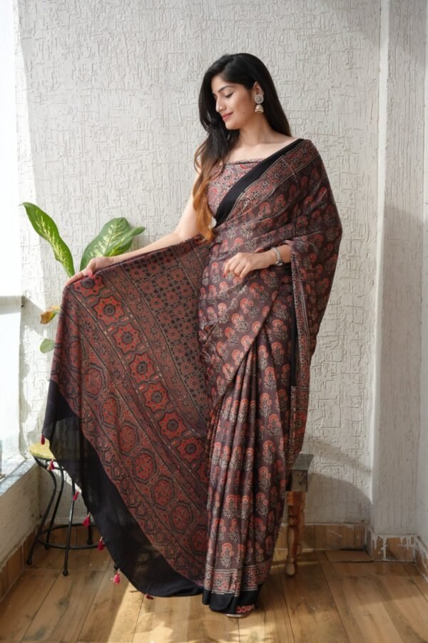 Woman draped in mauve-brown Ajrakh print modal silk saree with floral medallion pallu and black border
