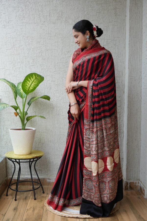 Woman wearing red and black striped Ajrakh print Modal silk saree with paisley pallu