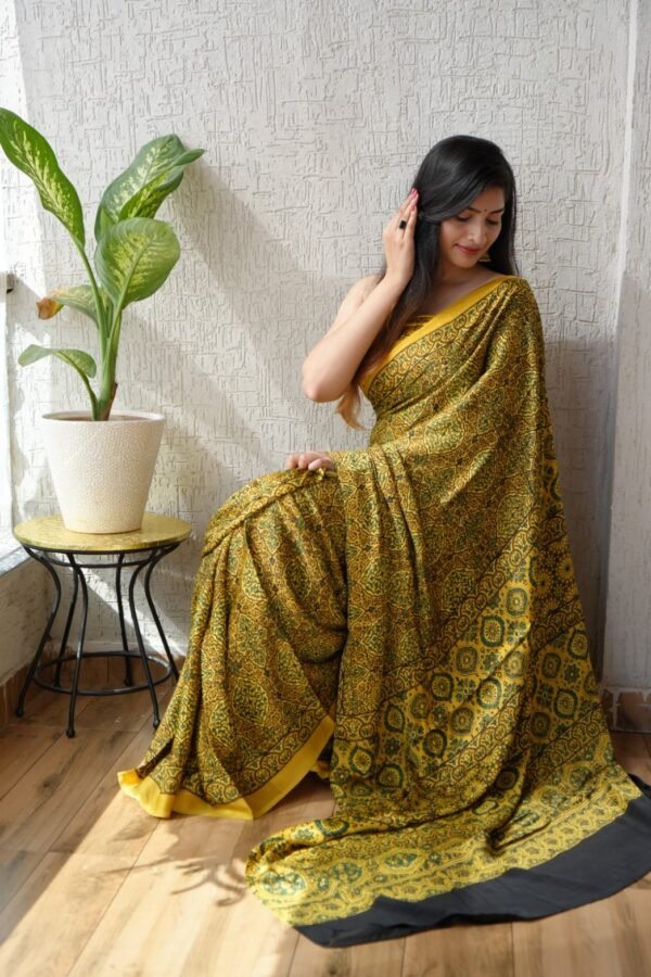 Woman draped in mustard yellow Ajrakh print Modal silk saree with floral medallion pattern and black border