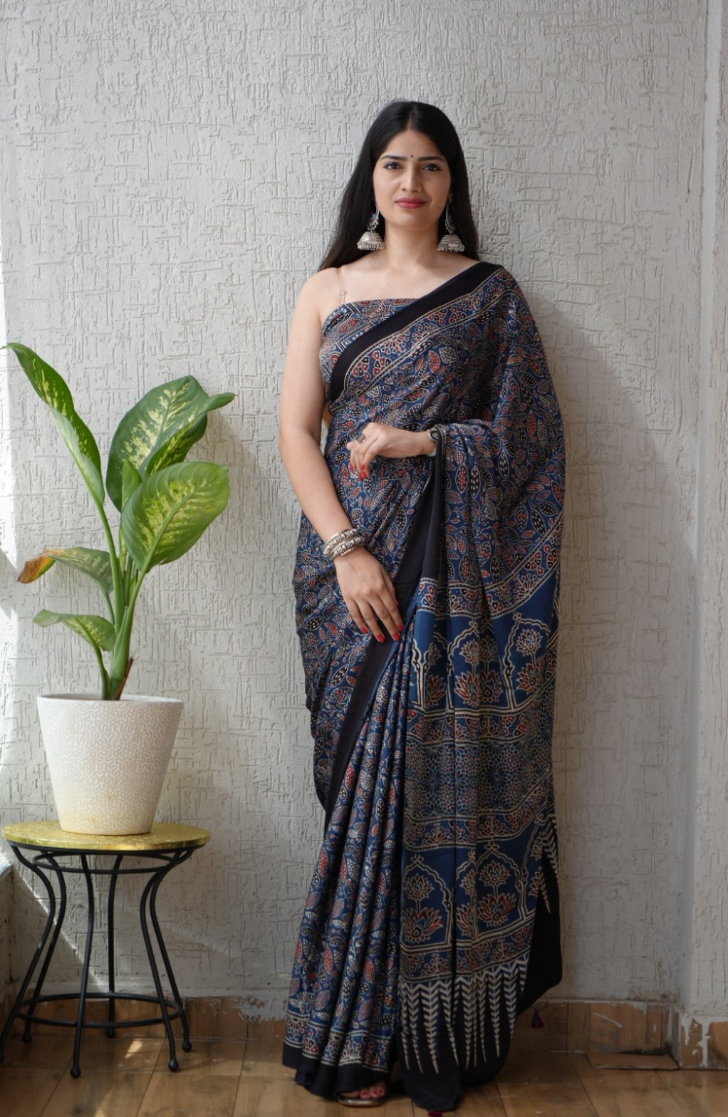 Woman wearing indigo blue Ajrakh print Modal Silk saree with black floral border