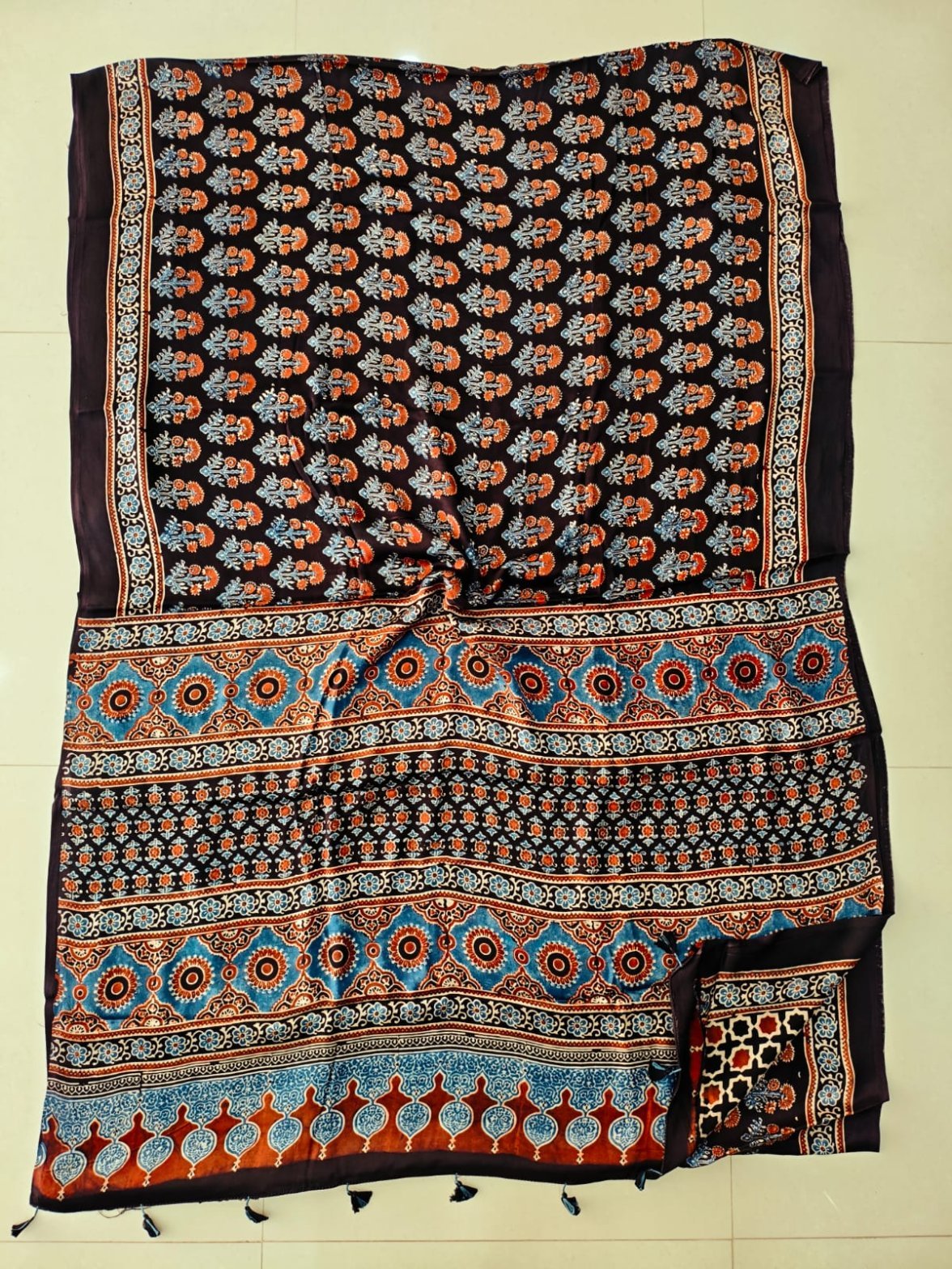 Dark brown Ajrakh print Modal silk saree with floral booti and blue medallion pallu border