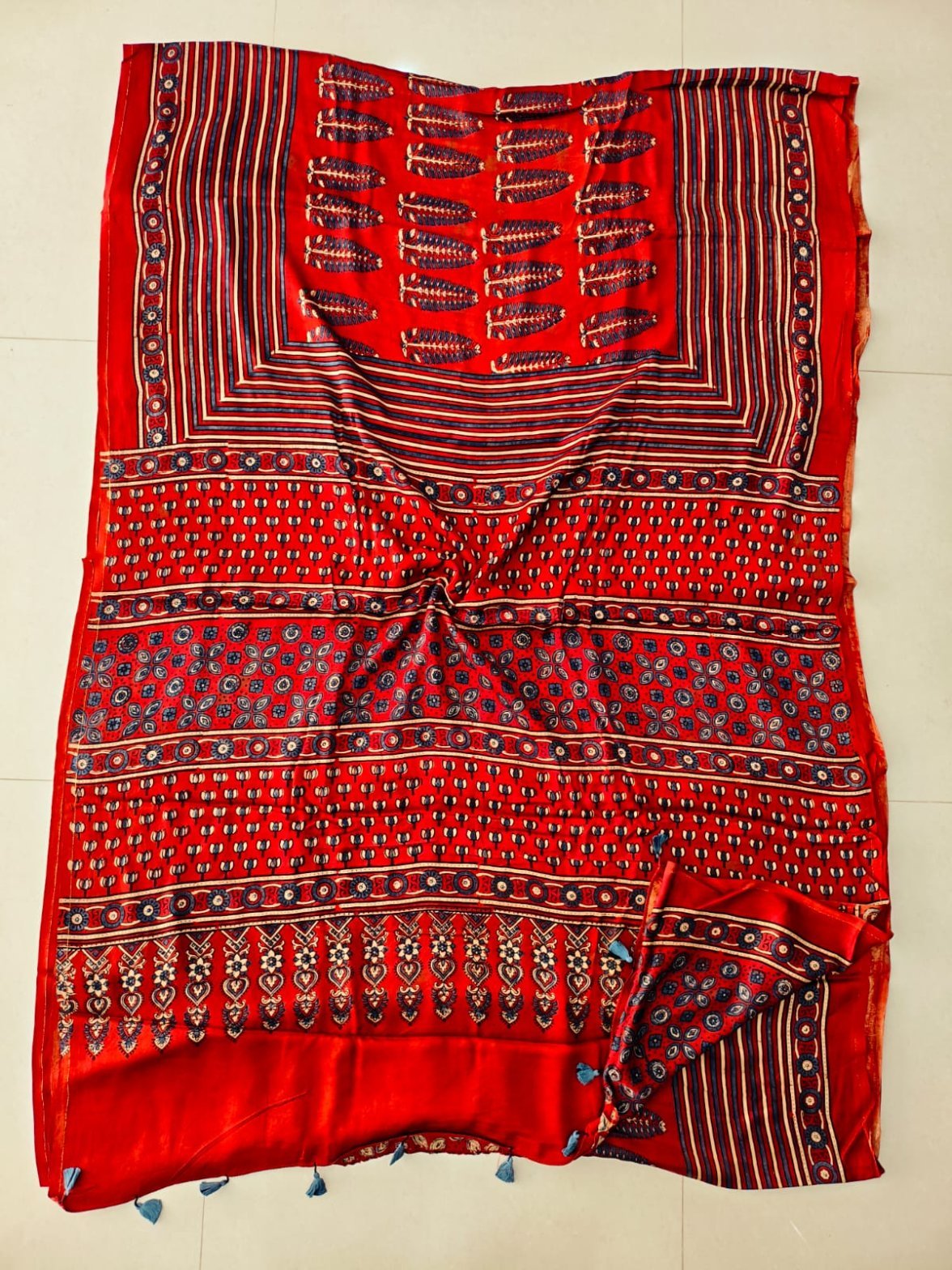 Red Ajrakh print pure modal silk saree with navy floral motifs and blue tassels