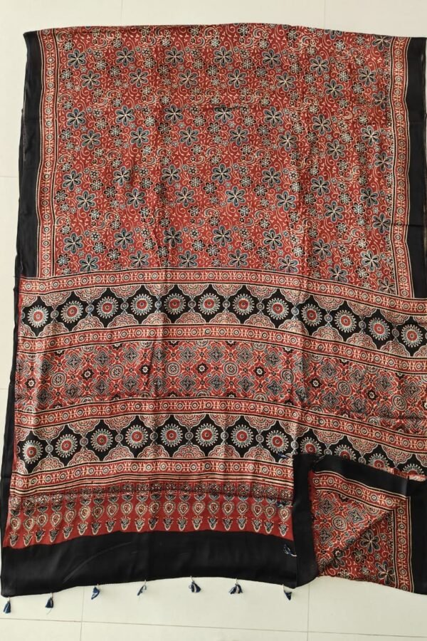 Rust red Ajrakh print pure Modal silk saree with black medallion border and navy tassels
