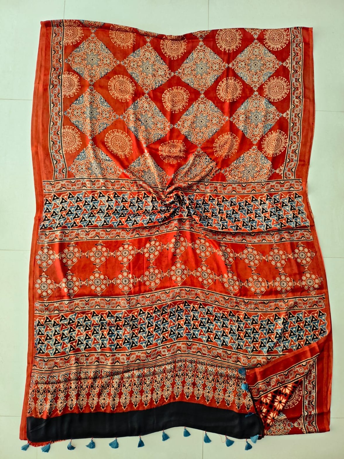 Rust red Ajrakh print pure Modal silk saree with diamond lattice and black tasseled border