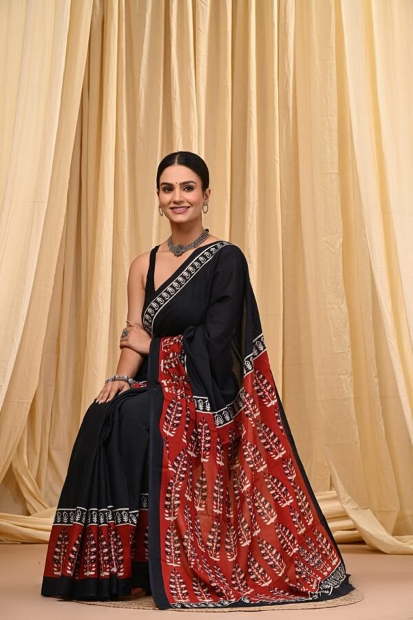 Woman draped in black Bagru print mul cotton saree with red fern motif pallu and border