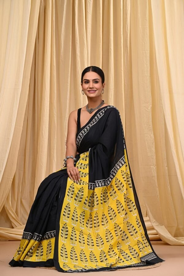 Woman in yellow and black leaf print Bagru mul cotton saree with floral border