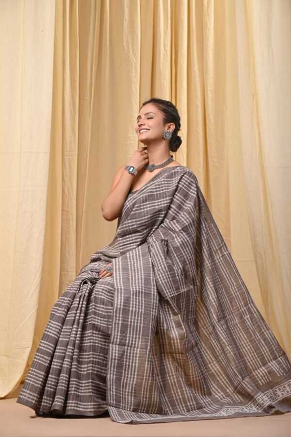 Woman draped in grey and white checked Bagru print mul cotton saree with geometric border
