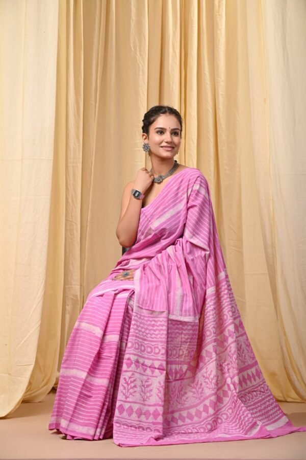 Woman wearing a pink Bagru print mul cotton saree with striped body and geometric border