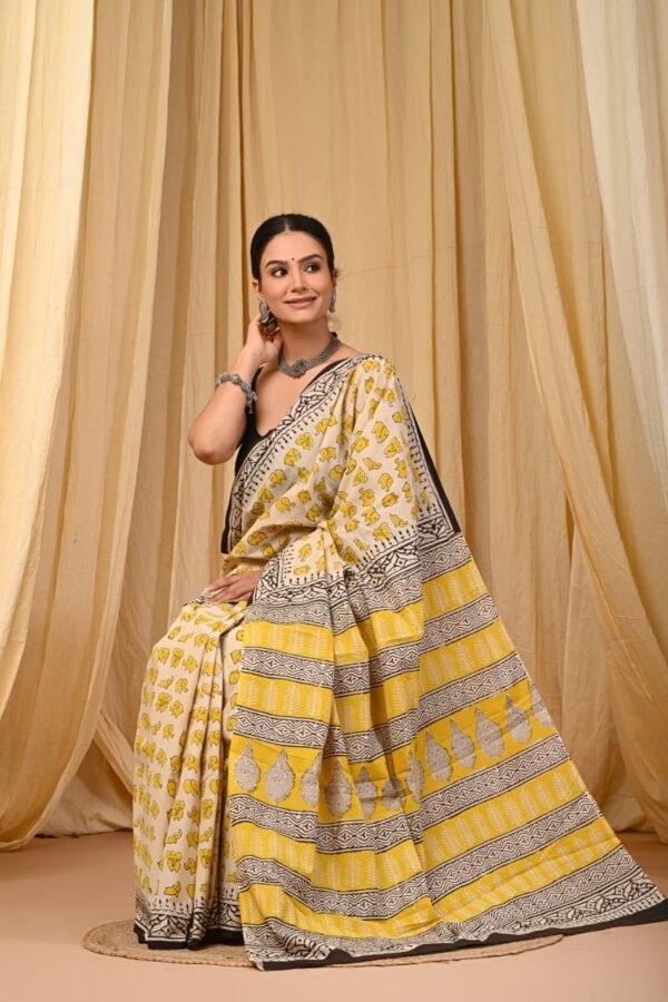 Woman draped in off-white mul cotton saree with yellow elephant motifs and black geometric border, Bagru print