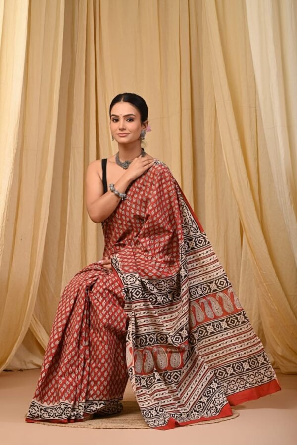 Woman draped in rust red mul cotton Bagru print saree with paisley booti and geometric border