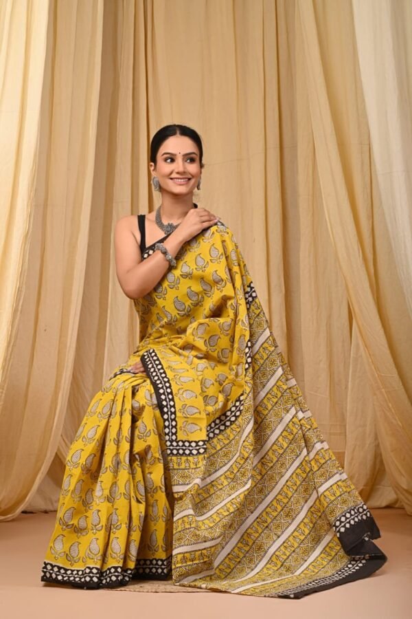 Woman draped in yellow Bagru print mul cotton saree with bird motifs and black-white striped border