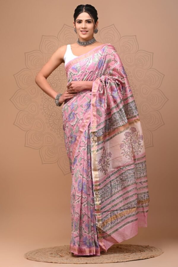 Woman wearing a pink hand block printed Maheshwari silk saree with floral motifs and gold border