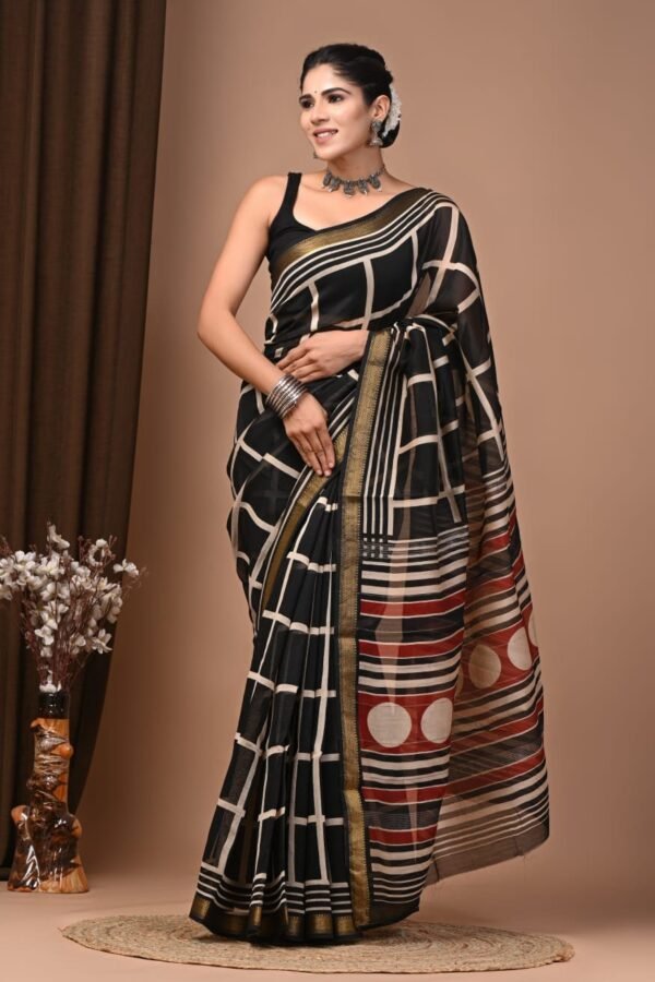 Woman draped in black geometric grid hand block printed Maheshwari silk saree with striped polka pallu