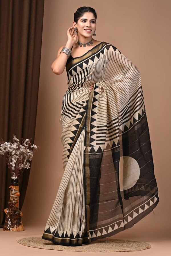 Woman draped in black and cream striped hand block printed Maheshwari silk saree with triangle border
