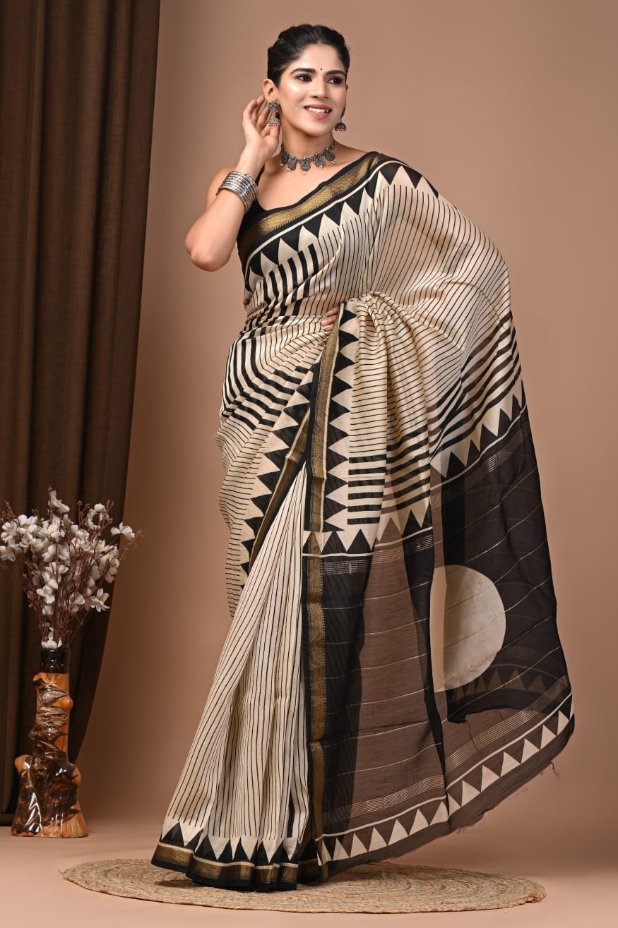 Woman draped in black and cream striped hand block printed Maheshwari silk saree with triangle border