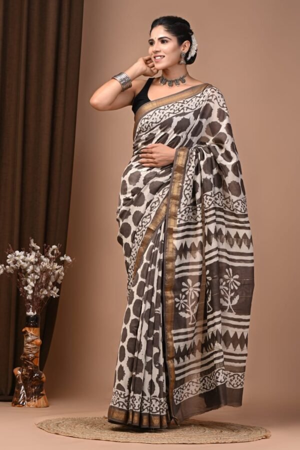 Woman draped in brown and off-white hand block printed Maheshwari silk saree with zari border