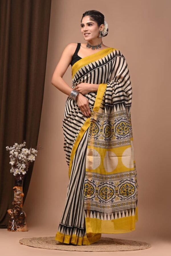 Woman draped in black and cream striped hand block printed Maheshwari silk saree with mustard pallu