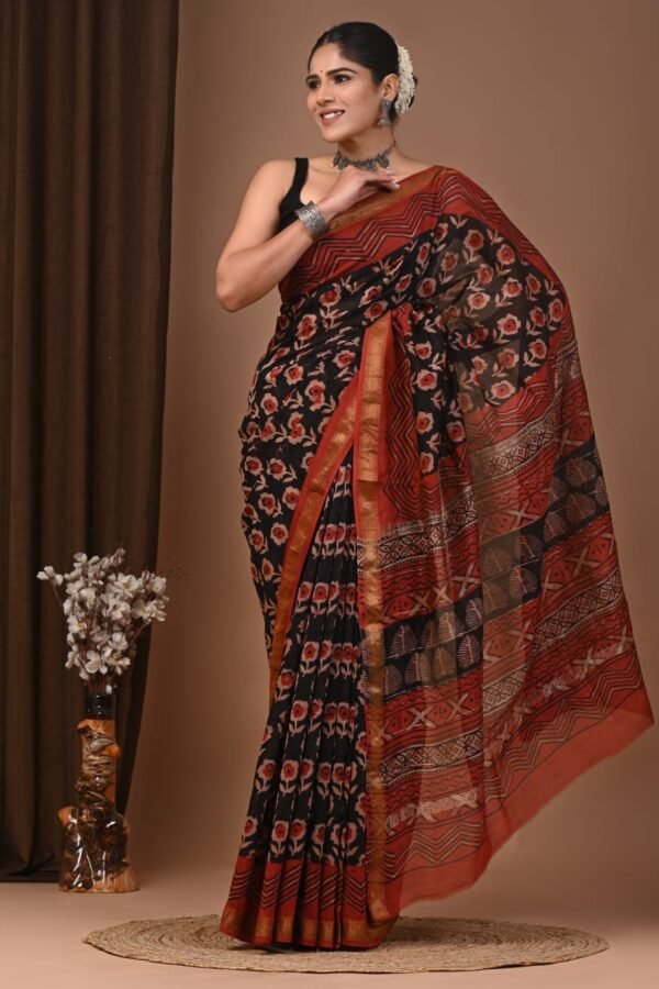 Woman draped in black hand block printed Maheshwari silk saree with rust floral motifs