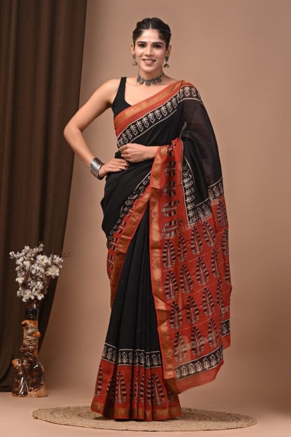 Woman wearing black hand block printed Maheshwari silk saree with rust-red leaf motif pallu