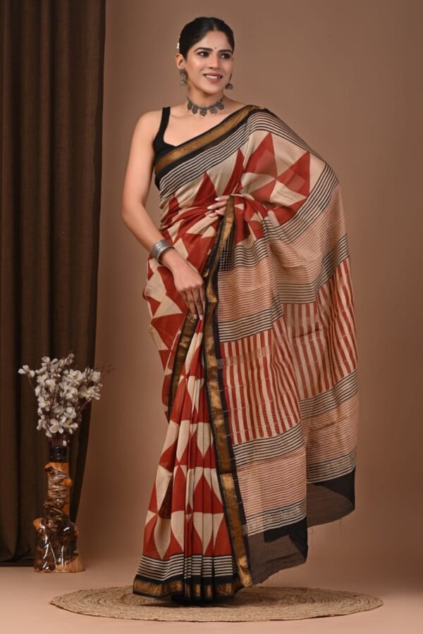 Woman wearing rust red and beige hand block printed Maheshwari silk saree with geometric pattern and gold border